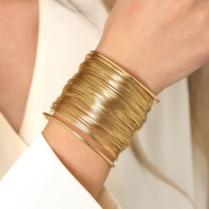 Uma Pulseira Dourada de Múltiplas Camadas Com Um Luxuoso Estilo Europeu e Americano, Apresentando Elementos Dourados Entrelaçados.